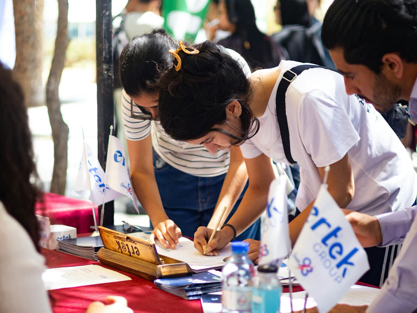 Applicants filling in forms at a registration desk